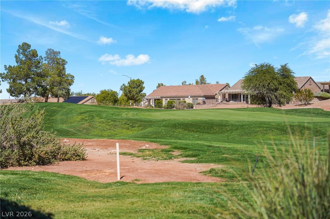 2738 Grand Forks Road, Henderson, NV 89052 Manicured green fairways stretch toward neighboring homes under a vast blue sky.