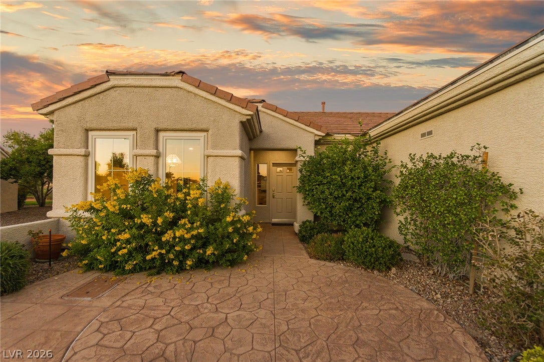 2738 Grand Forks Road, Henderson, NV 89052 Stamped concrete pathways lead to a welcoming entryway set against classic stucco exterior walls.