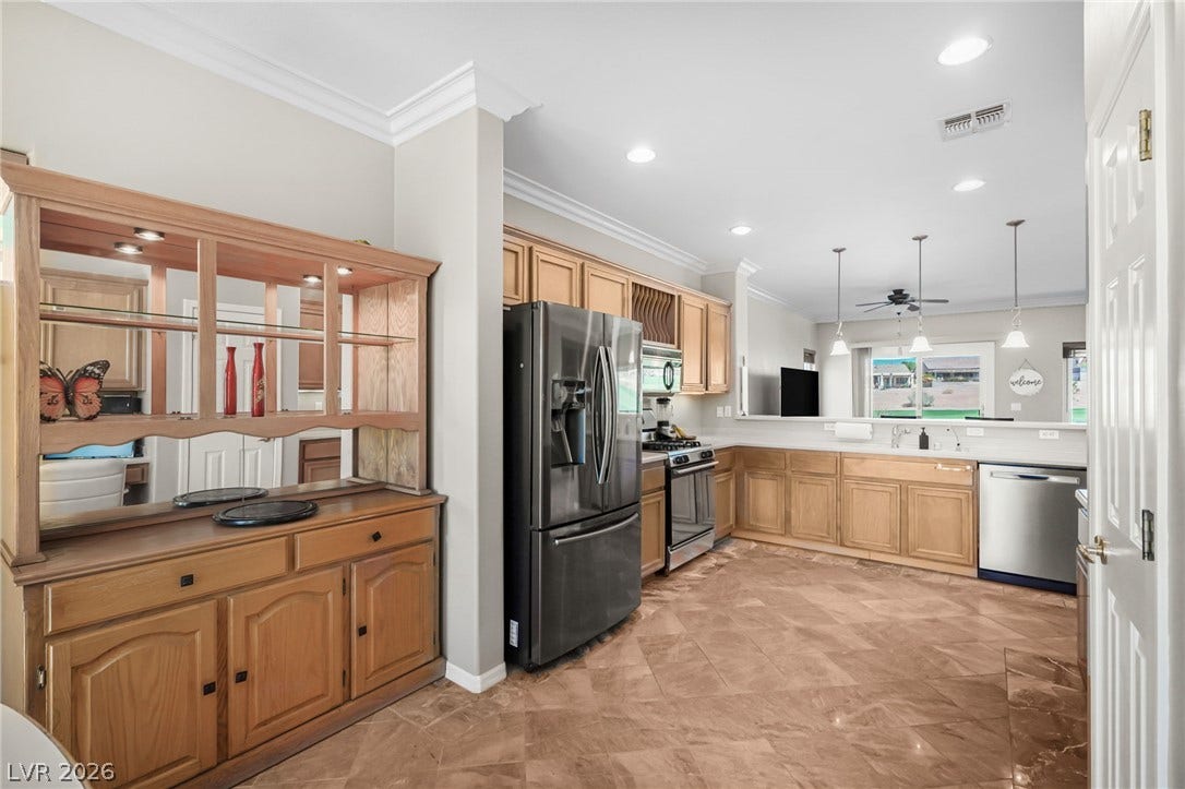 2738 Grand Forks Road, Henderson, NV 89052 Polished tile flooring and classic crown molding frame this spacious kitchen and service area.