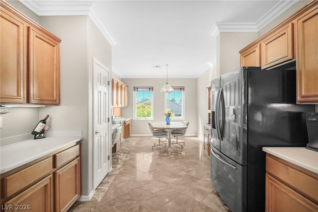 2738 Grand Forks Road, Henderson, NV 89052 Polished tile flooring and crown molding elevate this open kitchen and dining area.