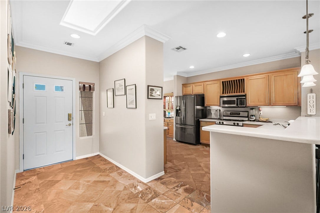2738 Grand Forks Road, Henderson, NV 89052 Polished stone tile floors guide your transition from the welcoming entry into a functional kitchen.