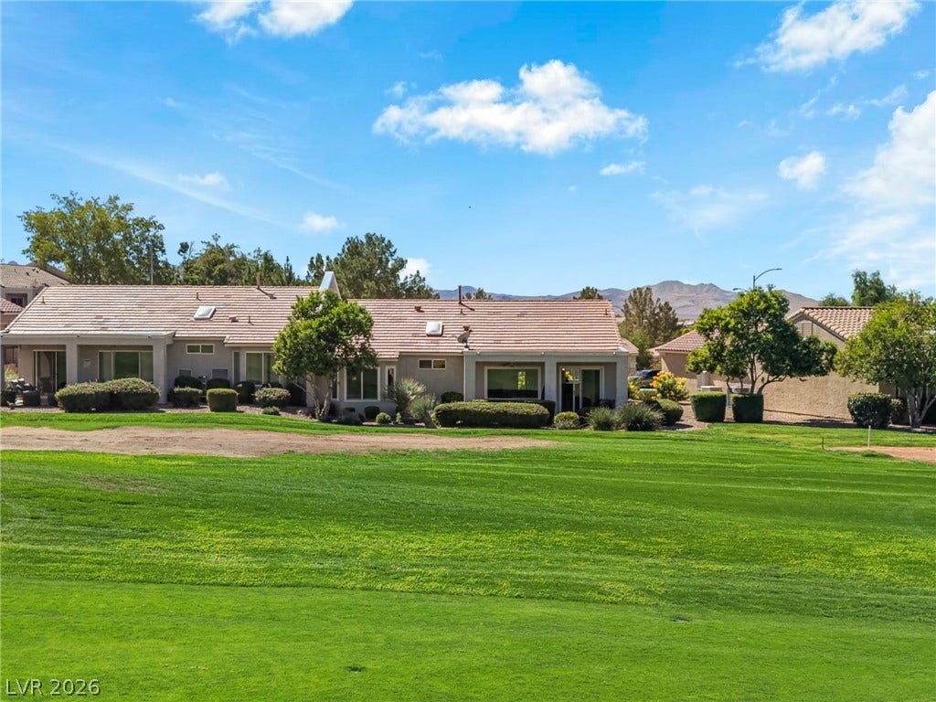 2738 Grand Forks Road, Henderson, NV 89052 A classic tile roof residence borders an expansive, manicured green space under open skies.