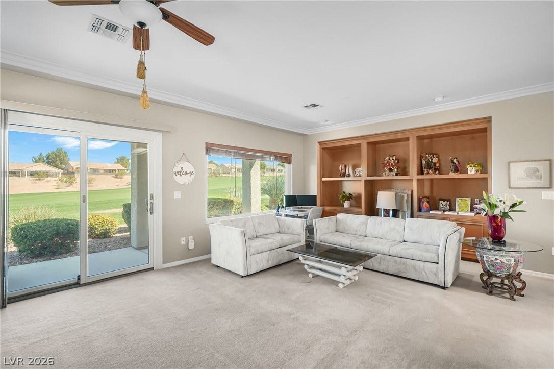 2738 Grand Forks Road, Henderson, NV 89052 Crown molding frames the neutral walls, plush carpeting, and expansive sliding glass doors.