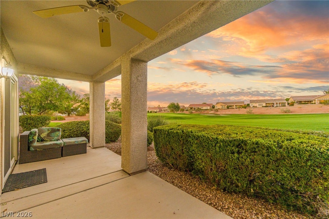 2738 Grand Forks Road, Henderson, NV 89052 An inviting covered patio looks out over a lush green fairway under vibrant twilight skies.