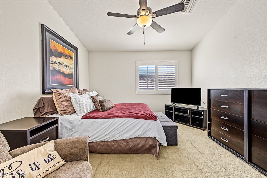 629 Lava Beds Way, North Las Vegas, NV 89084 A spacious bedroom features soft wall-to-wall carpeting and a wide window with integrated plantation shutters.