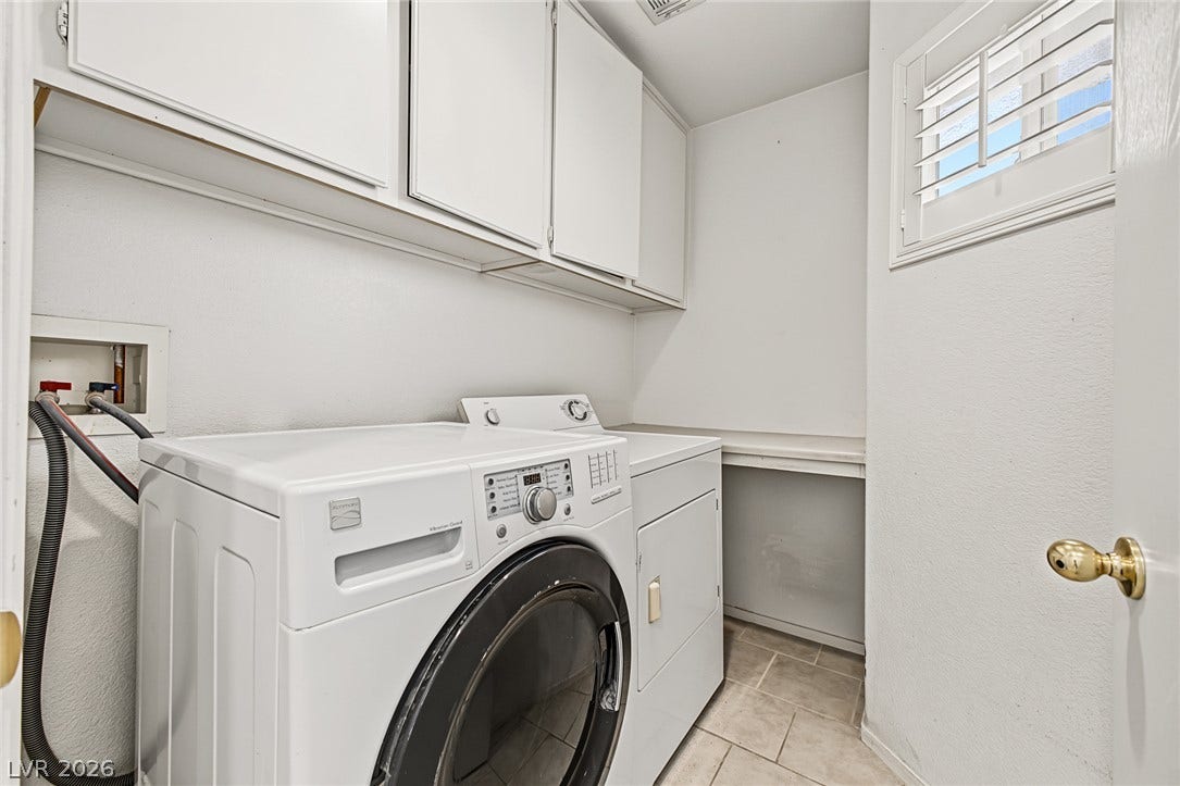 629 Lava Beds Way, North Las Vegas, NV 89084 White cabinetry and durable tile flooring define this functional utility space.