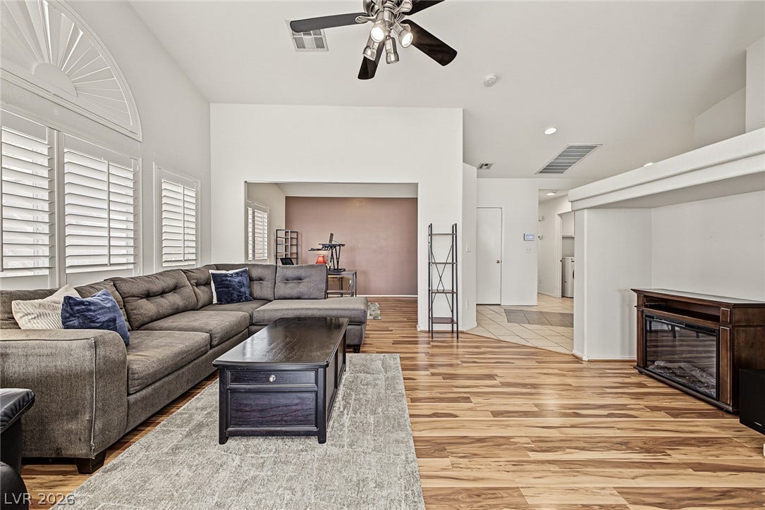 629 Lava Beds Way, North Las Vegas, NV 89084 Warm wood flooring and an airy vaulted ceiling define this welcoming living space.