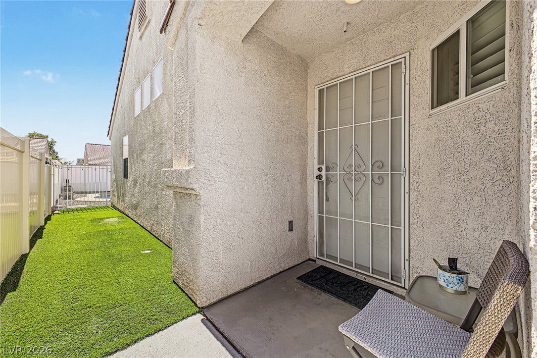 629 Lava Beds Way, North Las Vegas, NV 89084 Textured stucco walls frame a private entryway bordering a neat stretch of green lawn.