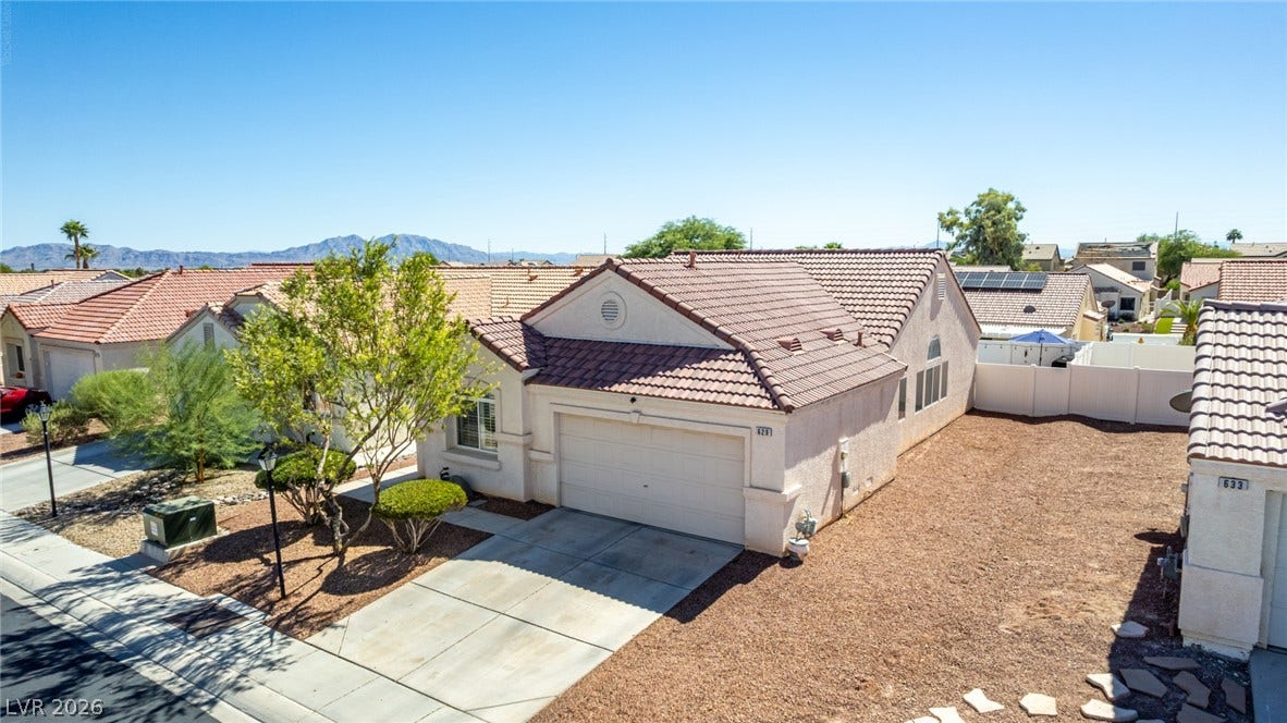 629 Lava Beds Way, North Las Vegas, NV 89084 Spanish tile roofing and an attached garage define this classic desert-style residence.