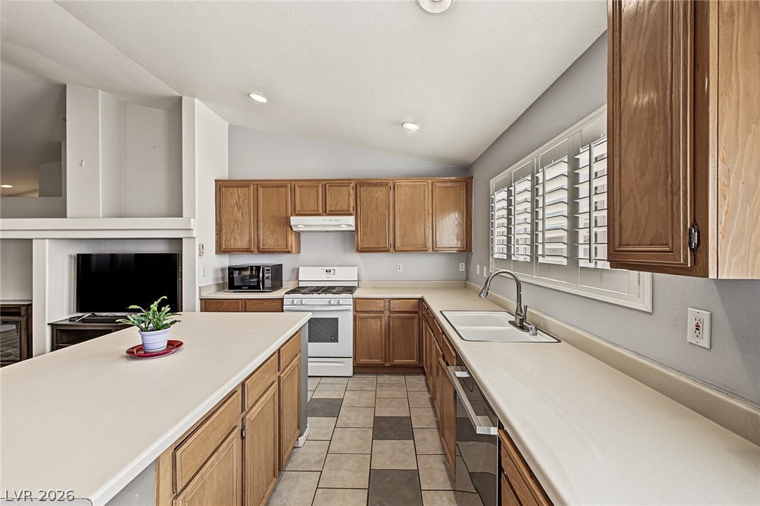 629 Lava Beds Way, North Las Vegas, NV 89084 Warm wood cabinetry and tile flooring define this functional kitchen layout.
