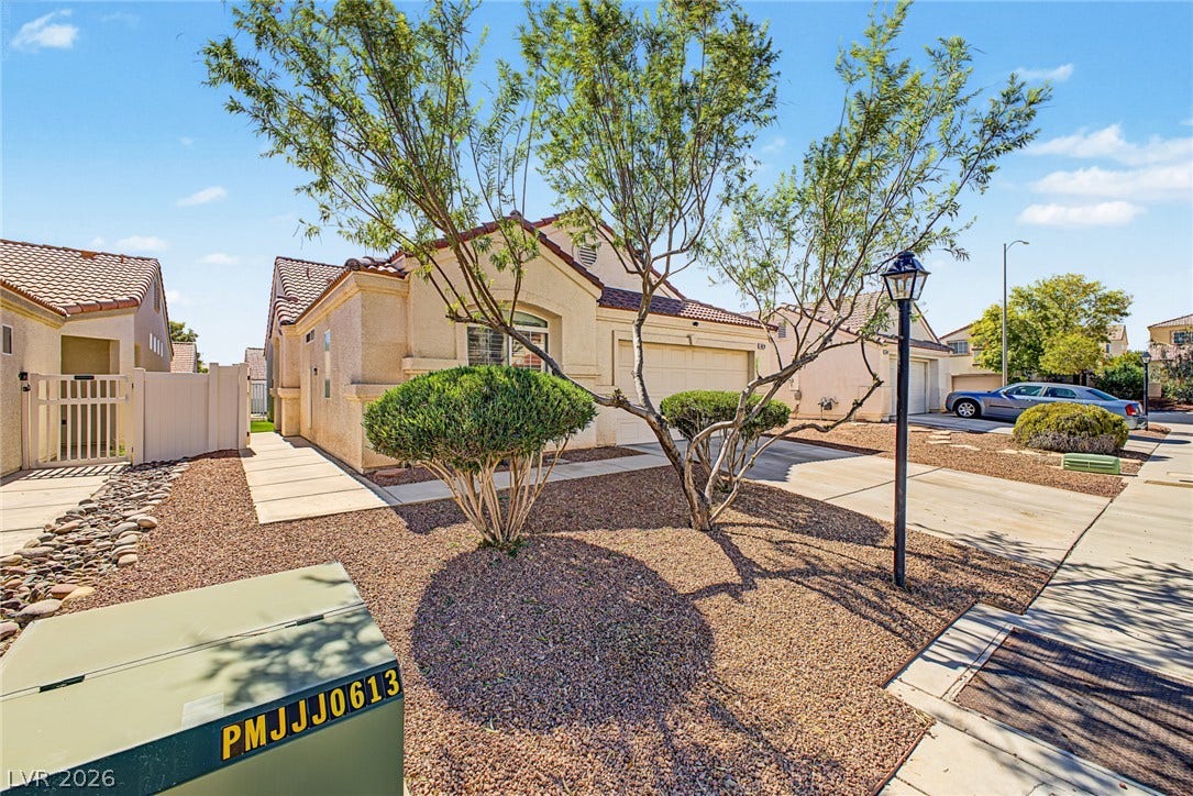 629 Lava Beds Way, North Las Vegas, NV 89084 An inviting stucco exterior features tile roofing and neat desert-inspired landscaping alongside a concrete driveway.