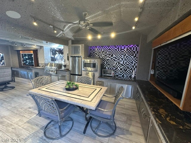 8175 Arville Street, #400, Las Vegas, NV 89139 Textured ceilings and stone-patterned tile floors frame this modern interior recreation and dining space.