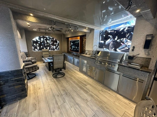 8175 Arville Street, #400, Las Vegas, NV 89139 An outdoor kitchen features durable stone-look flooring and built-in stainless steel appliances.