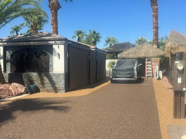 8175 Arville Street, #400, Las Vegas, NV 89139 A spacious driveway area framed by mature palm trees and unique architectural structures.