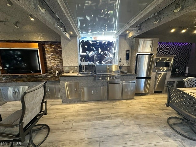 8175 Arville Street, #400, Las Vegas, NV 89139 Premium wood-look tile flooring spans a fully equipped kitchen with integrated stainless steel appliances.