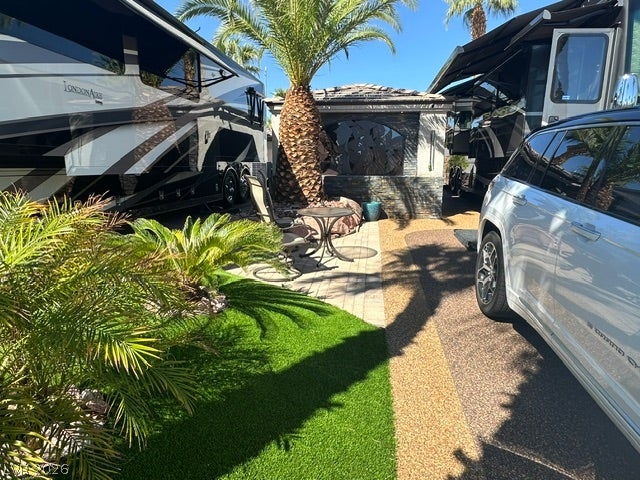 8175 Arville Street, #400, Las Vegas, NV 89139 Lush tropical plantings frame a paved patio area situated between level parking spaces.