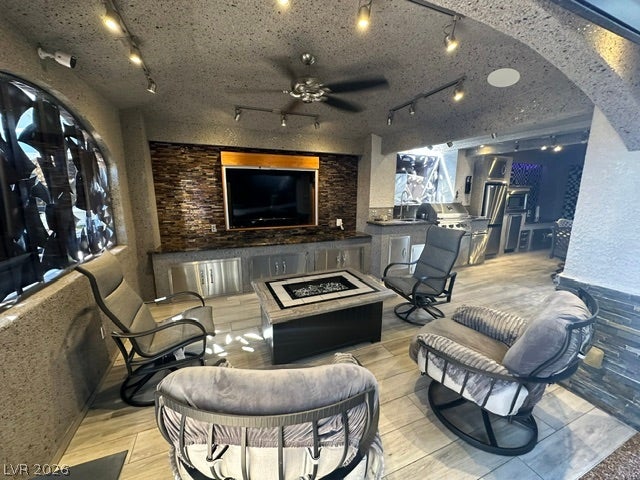 8175 Arville Street, #400, Las Vegas, NV 89139 An inviting covered patio features tiled flooring, stacked stone accents, and an integrated outdoor kitchen.