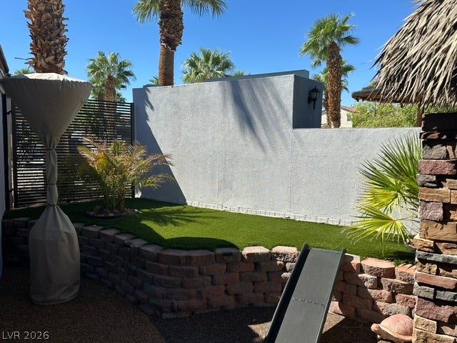 8175 Arville Street, #400, Las Vegas, NV 89139 A raised lawn area sits framed by stone retaining walls beneath a bright desert sky.