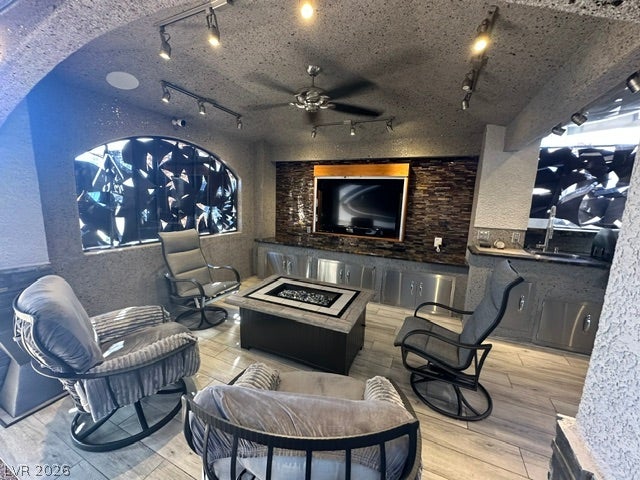 8175 Arville Street, #400, Las Vegas, NV 89139 A stone-textured fireplace lounge opens to a built-in outdoor kitchen with matching cabinetry.