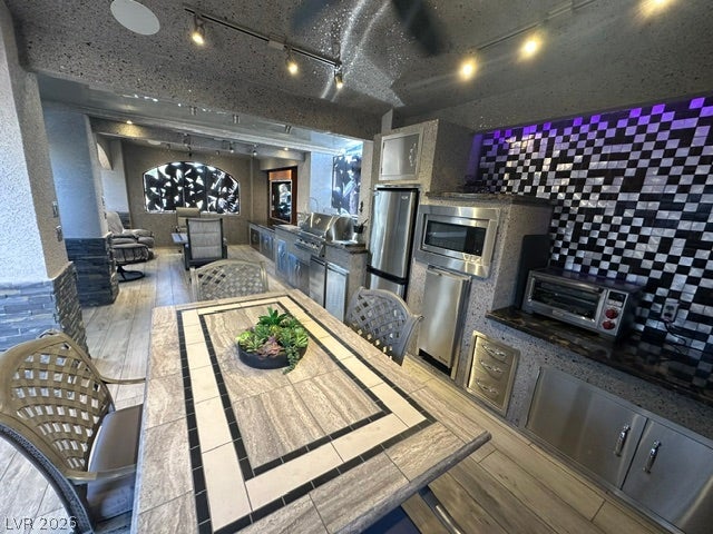 8175 Arville Street, #400, Las Vegas, NV 89139 Custom stonework and integrated appliances define this modern, covered outdoor cooking and dining space.