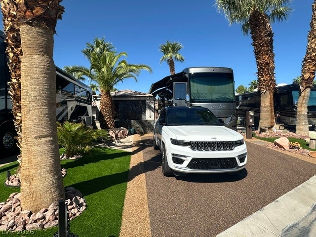 8175 Arville Street, #400, Las Vegas, NV 89139 Towering palm trees flank the paved driveway under a clear blue desert sky.