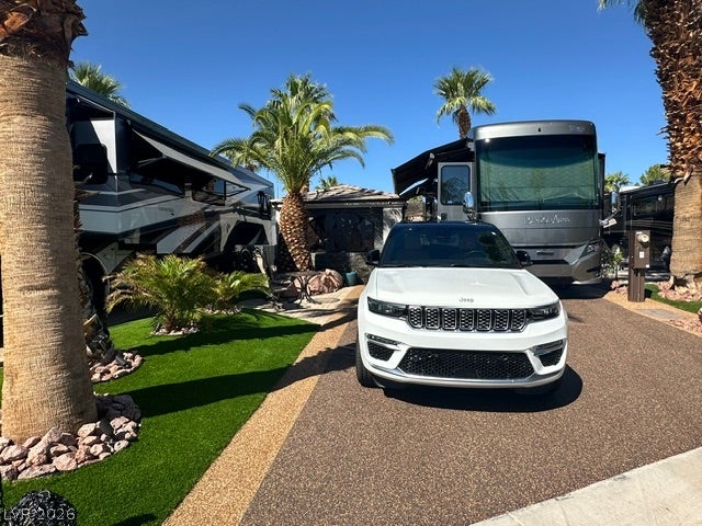 8175 Arville Street, #400, Las Vegas, NV 89139 Lush palm trees and neat landscaping frame a paved driveway suited for recreational vehicles.