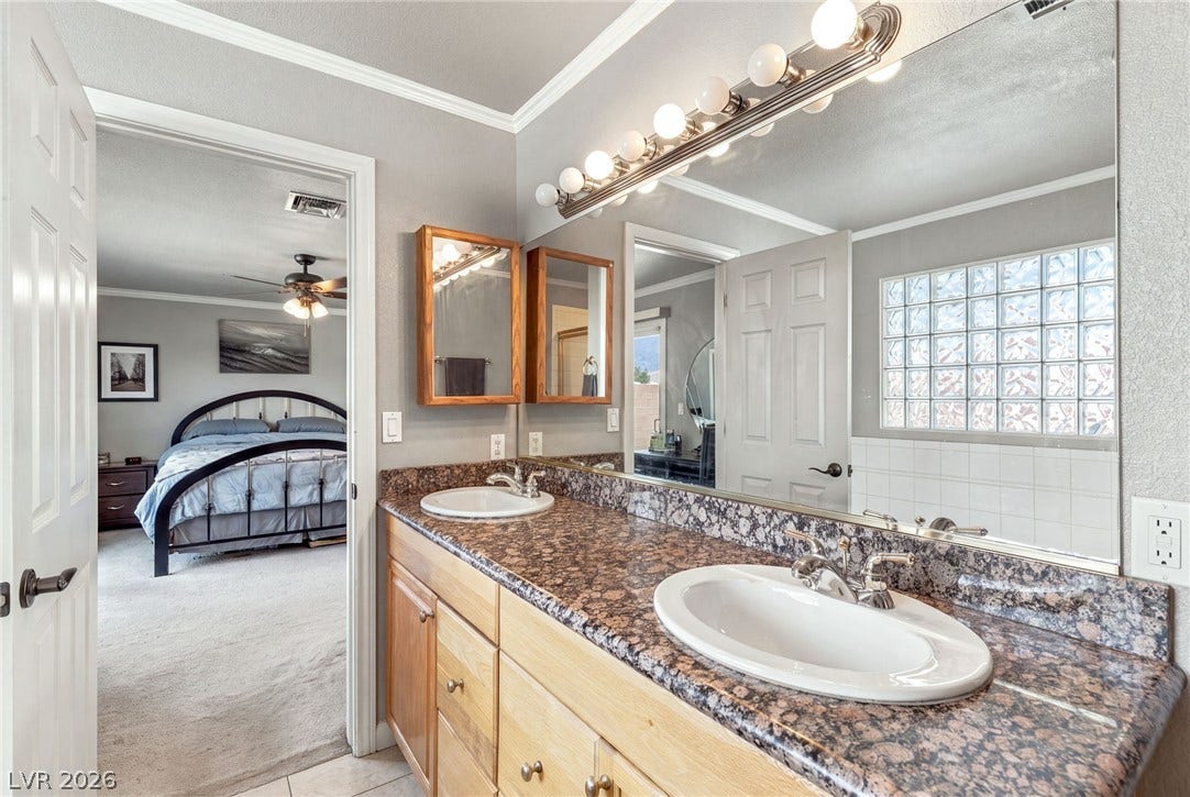 6560 Whispering Sands Drive, Las Vegas, NV 89131 Granite counters and a wide double vanity elevate this classic bathroom design.