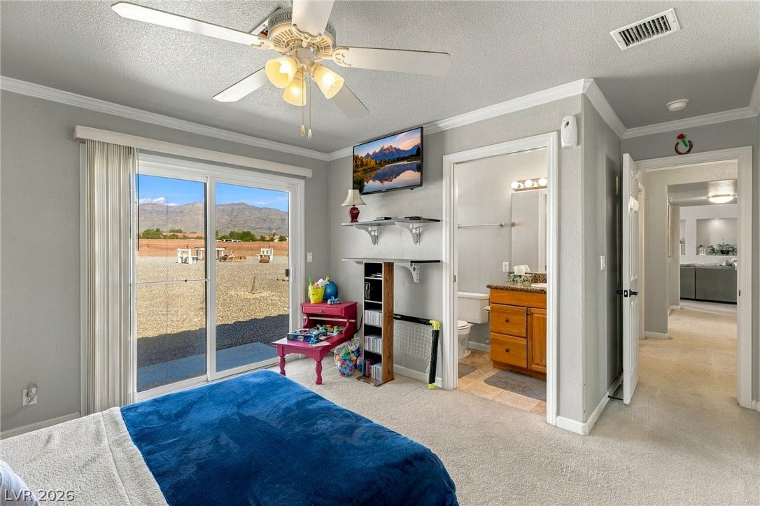 6560 Whispering Sands Drive, Las Vegas, NV 89131 Sliding glass doors open directly to the outdoors from this carpeted bedroom suite.
