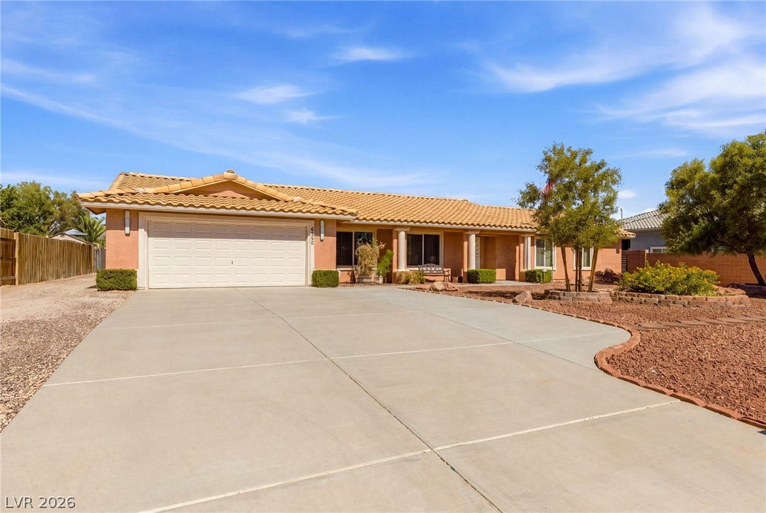 6560 Whispering Sands Drive, Las Vegas, NV 89131 An expansive concrete driveway leads to this classic single-level residence with tile roofing.