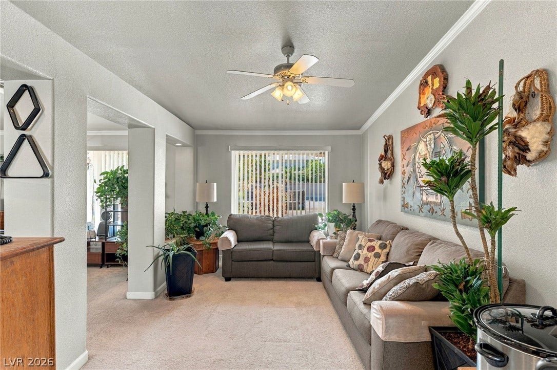 6560 Whispering Sands Drive, Las Vegas, NV 89131 Crown molding and plush carpeting define this comfortable main-level living space.