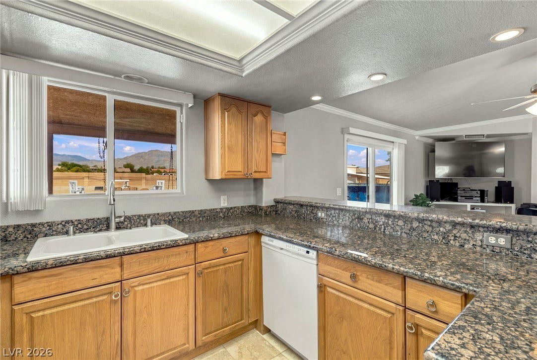 6560 Whispering Sands Drive, Las Vegas, NV 89131 Polished granite countertops complement solid oak cabinetry in this functional open-concept layout.