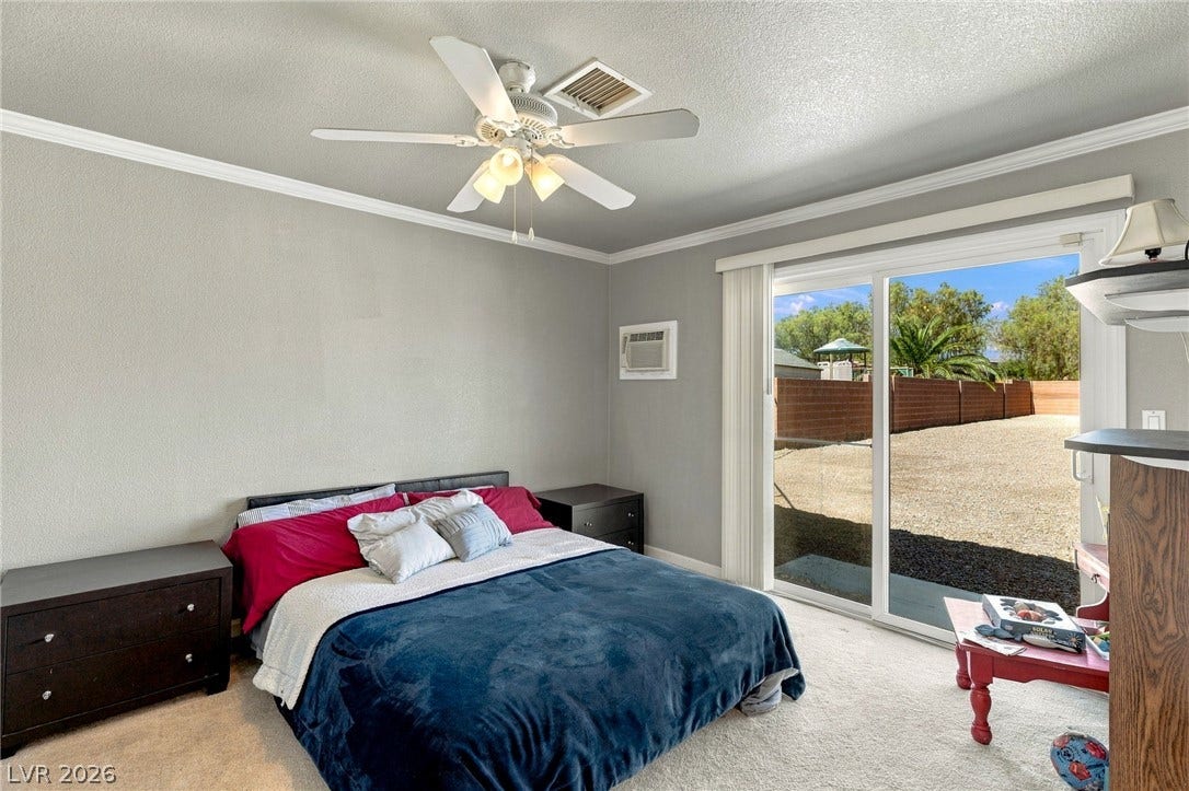 6560 Whispering Sands Drive, Las Vegas, NV 89131 Sliding glass doors open directly to the outdoor yard from this carpeted bedroom.