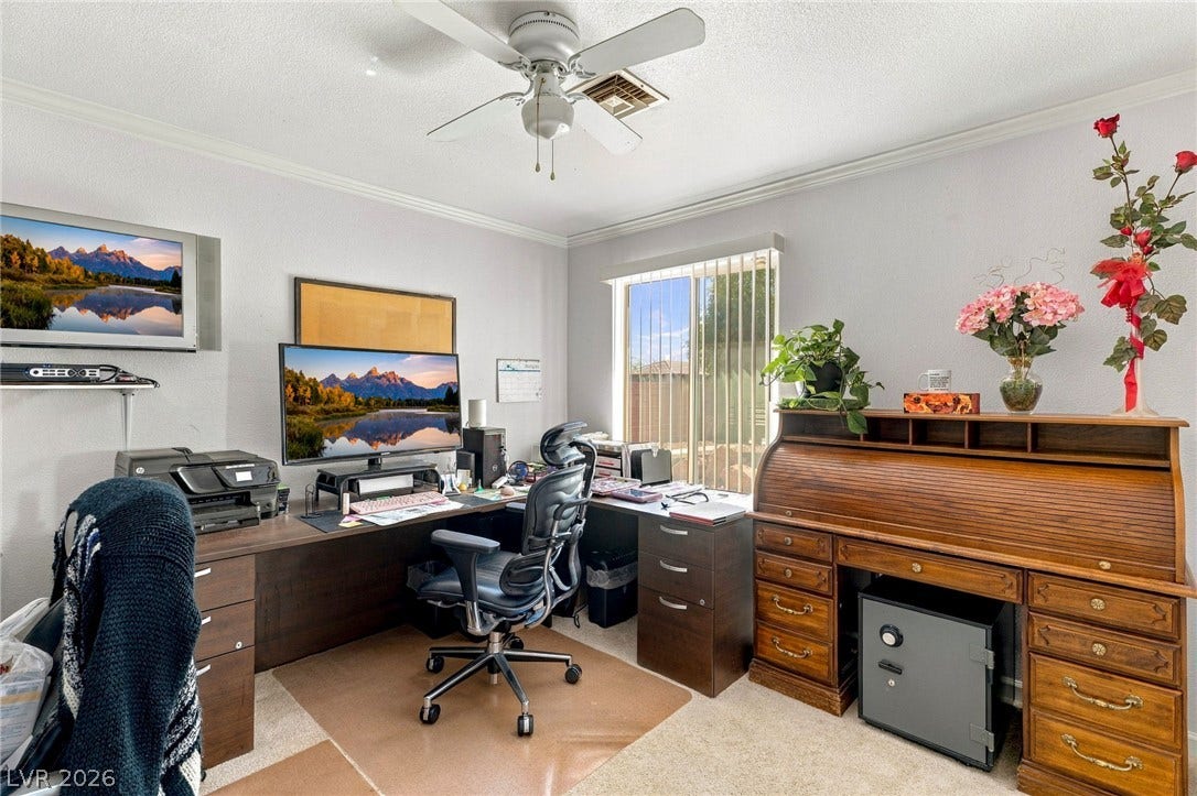 6560 Whispering Sands Drive, Las Vegas, NV 89131 An integrated workspace highlights crown molding, plush carpeting, and a large window facing the yard.