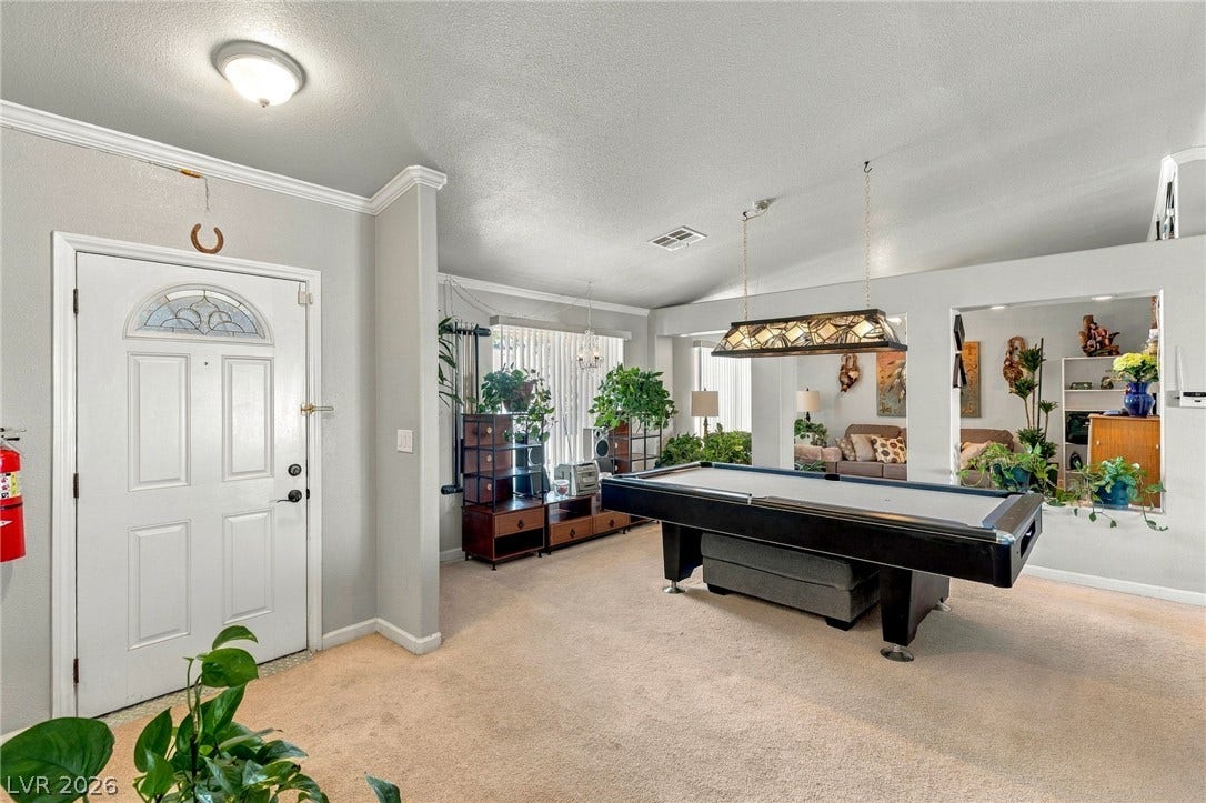 6560 Whispering Sands Drive, Las Vegas, NV 89131 Crown molding and plush carpeting define this versatile entry and recreation space.