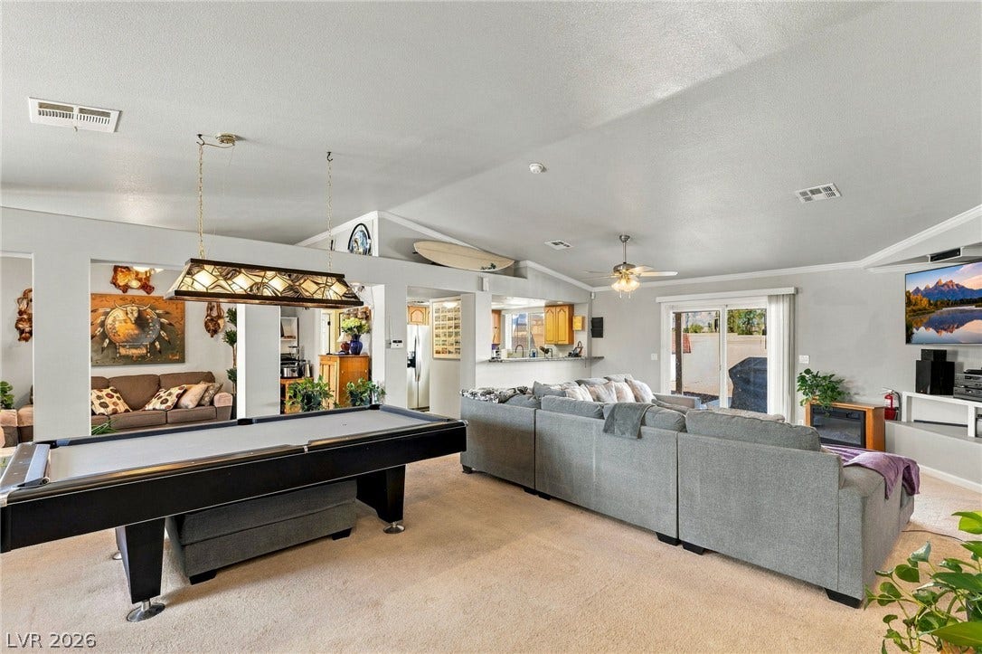 6560 Whispering Sands Drive, Las Vegas, NV 89131 An open layout connects the living spaces under a vaulted ceiling.