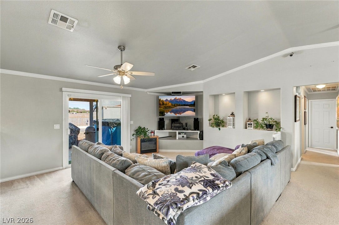 6560 Whispering Sands Drive, Las Vegas, NV 89131 Sliding doors open to the patio from this carpeted living room with recessed display niches.