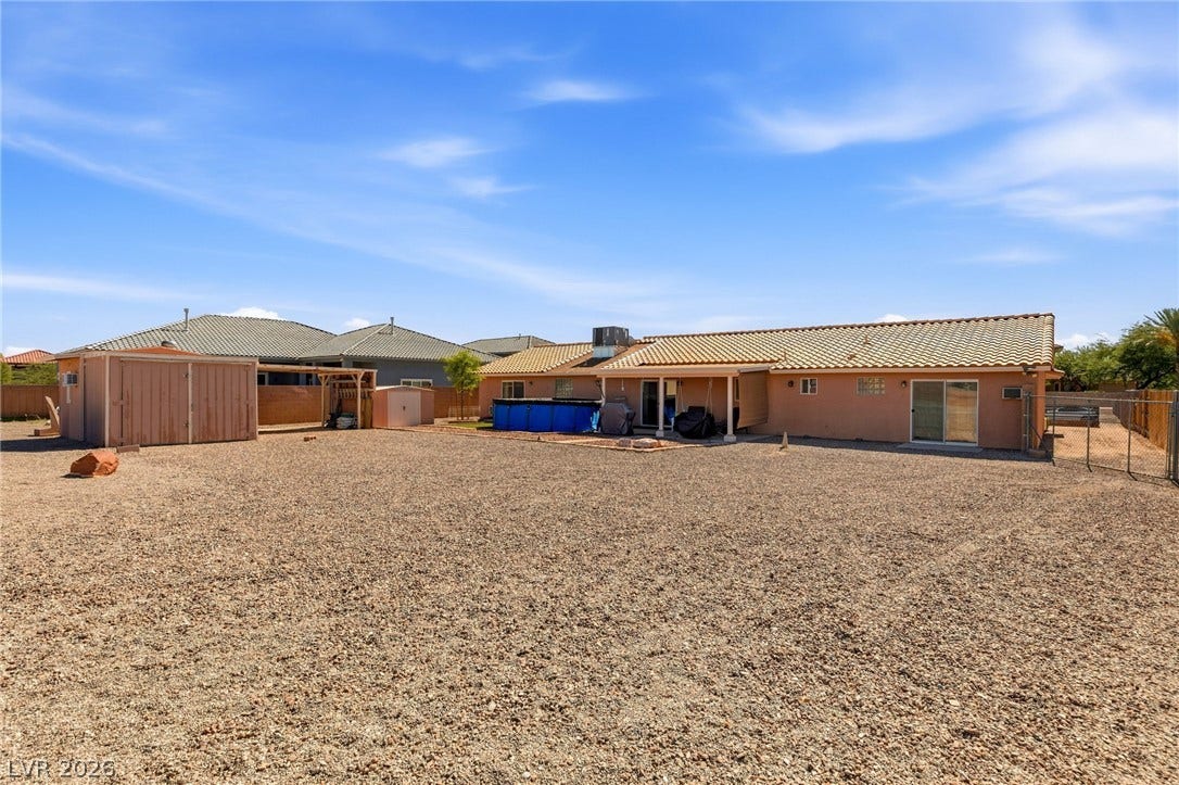 6560 Whispering Sands Drive, Las Vegas, NV 89131 A spacious gravel backyard offers plenty of open space and includes convenient storage sheds.