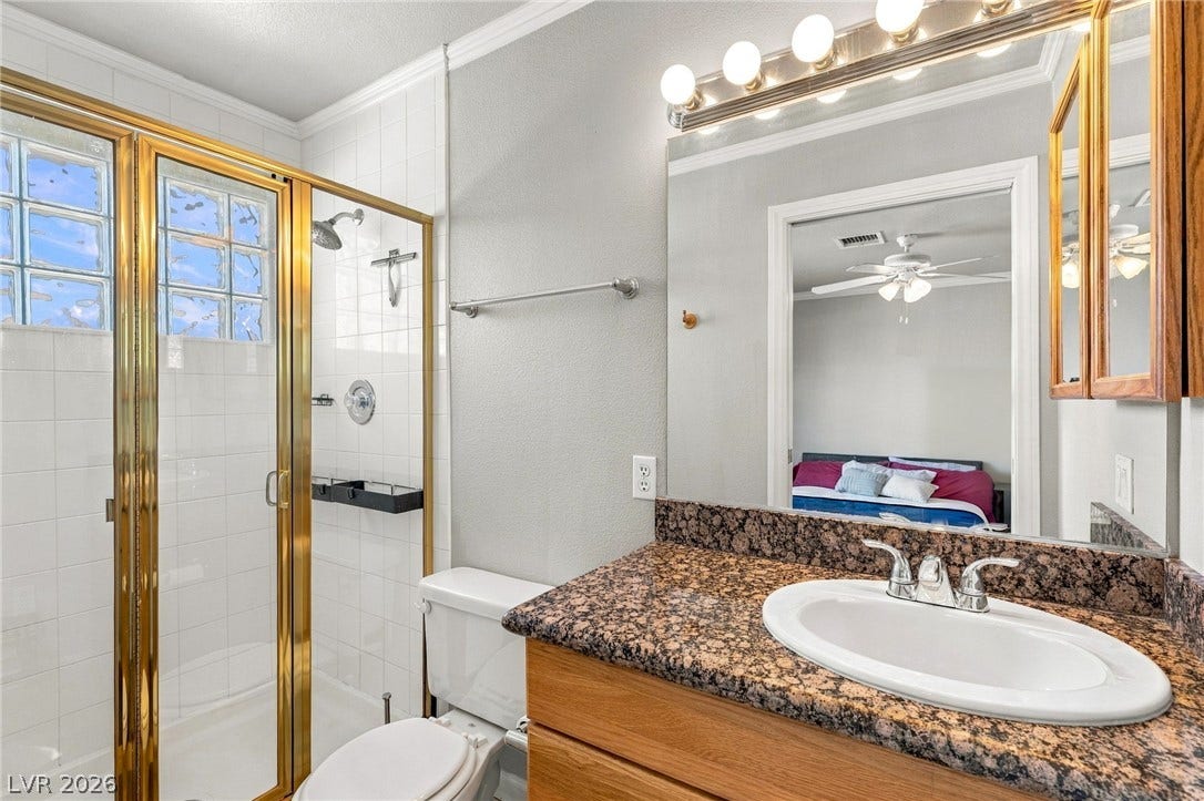 6560 Whispering Sands Drive, Las Vegas, NV 89131 Polished granite countertops and classic tiling define this well-appointed bathroom space.