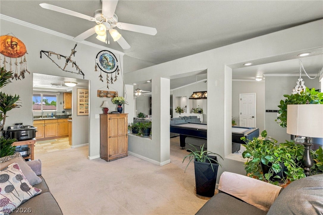 6560 Whispering Sands Drive, Las Vegas, NV 89131 An open-concept living area flows seamlessly into adjacent rooms with carpeted flooring throughout.