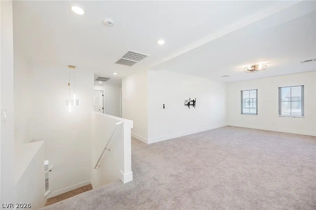 8683 S Black Cordon Road, Las Vegas, NV 89139 Plush carpeting and tall windows define this open second-level living area.