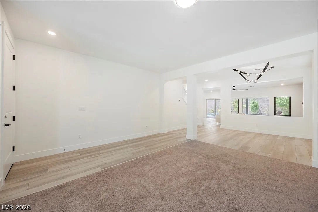 8683 S Black Cordon Road, Las Vegas, NV 89139 An open-concept layout features clean lines and a seamless blend of carpet and wood-look flooring.