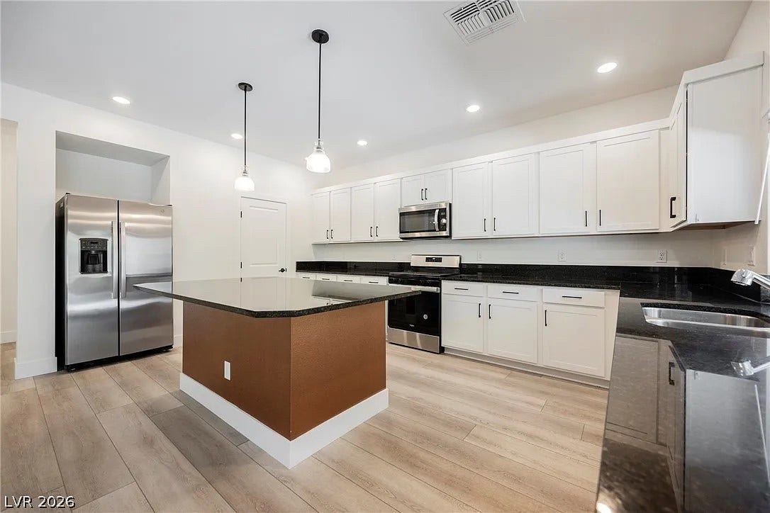 8683 S Black Cordon Road, Las Vegas, NV 89139 Polished stone countertops complement clean cabinetry and a central island in this spacious kitchen.