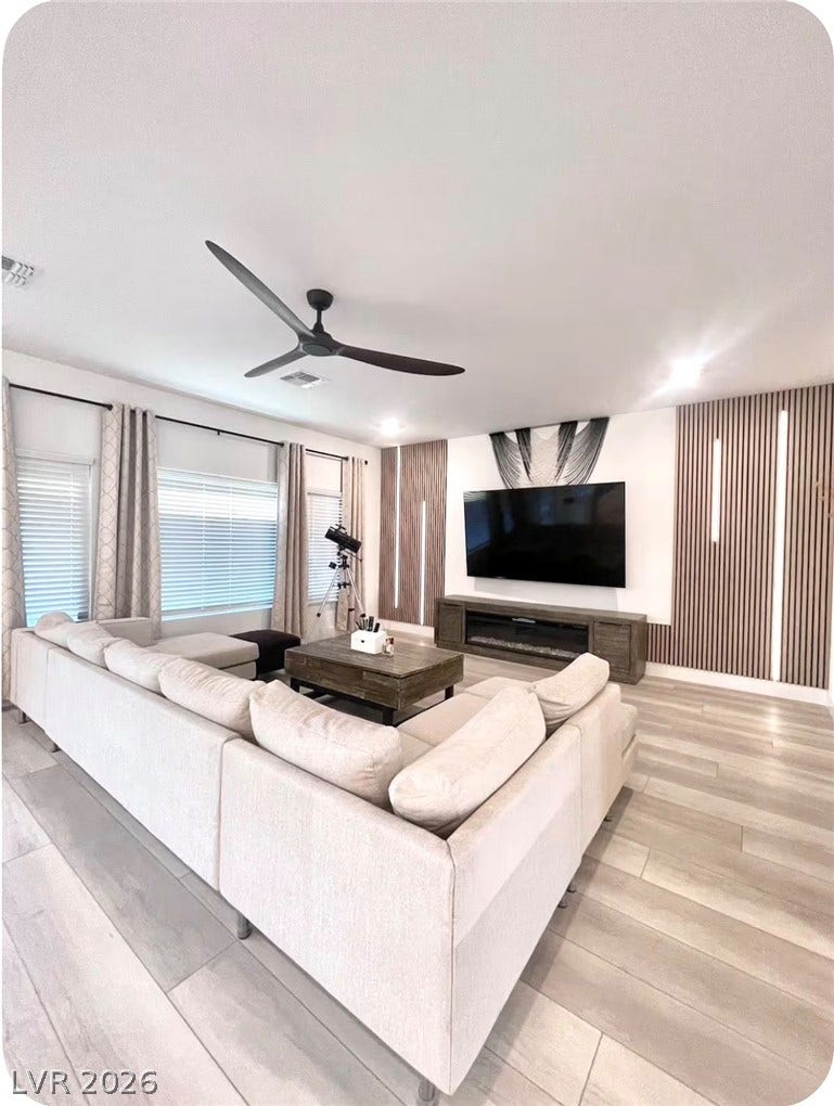 8683 S Black Cordon Road, Las Vegas, NV 89139 Smooth wood-look flooring and custom wall paneling create a modern, inviting atmosphere.