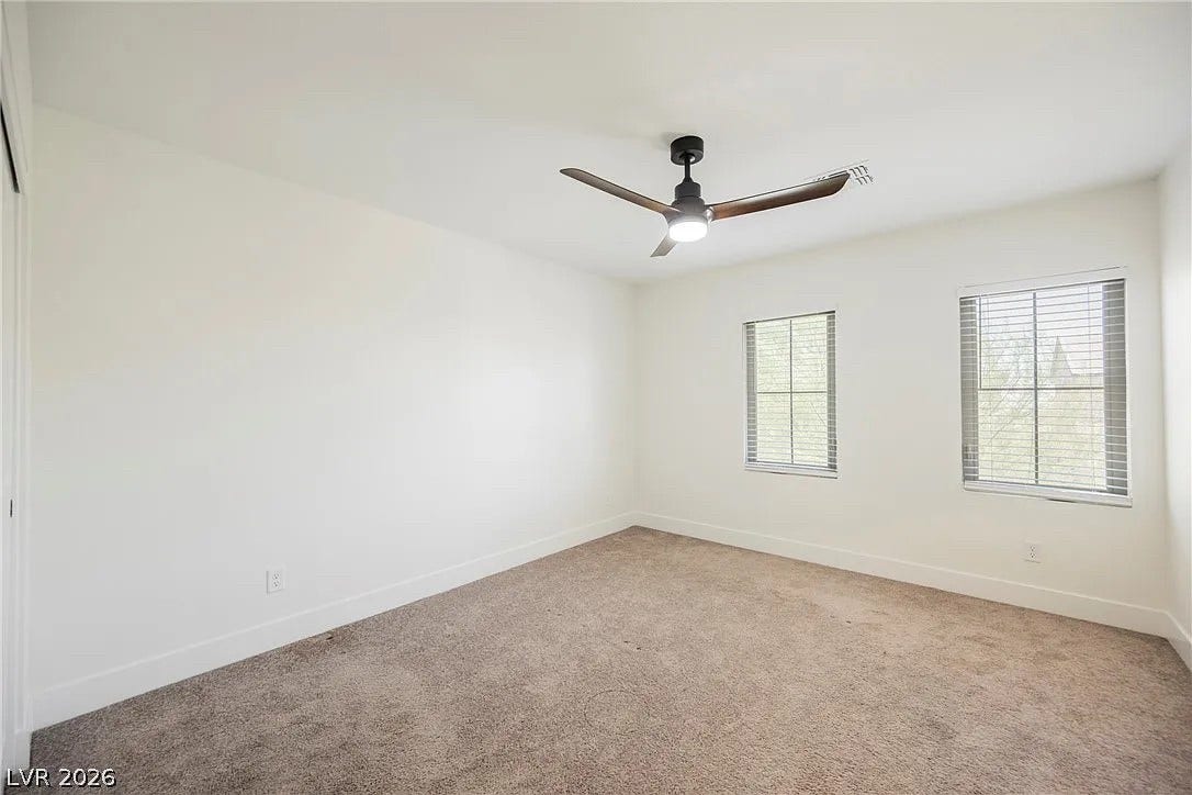8683 S Black Cordon Road, Las Vegas, NV 89139 Plush carpeting and natural light highlight this comfortable bedroom space.