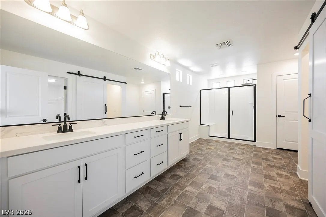 8683 S Black Cordon Road, Las Vegas, NV 89139 A long double vanity with stone counters anchors this spacious, modern bathroom.