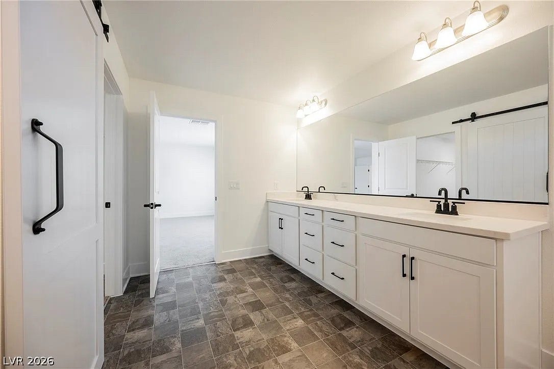 8683 S Black Cordon Road, Las Vegas, NV 89139 Double vanity highlights this clean bathroom setup featuring dark tiled flooring and a massive mirror.