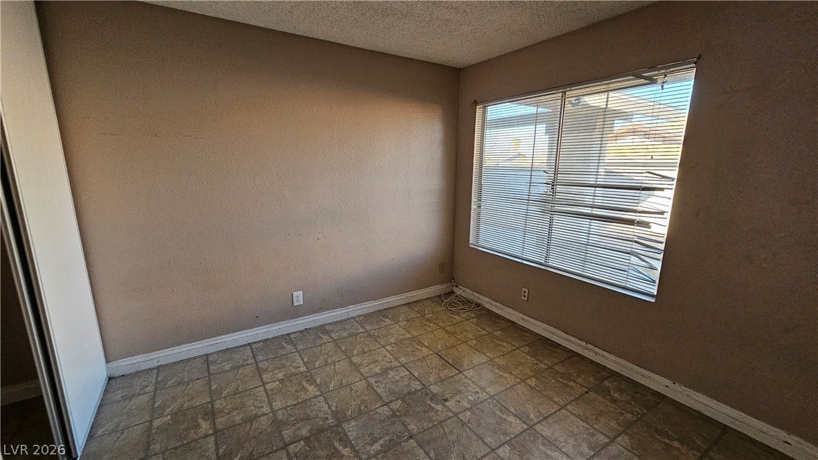 6777 Ledgewood Drive, Las Vegas, NV 89103 Natural light pours through a large window into this versatile tile-floored room.