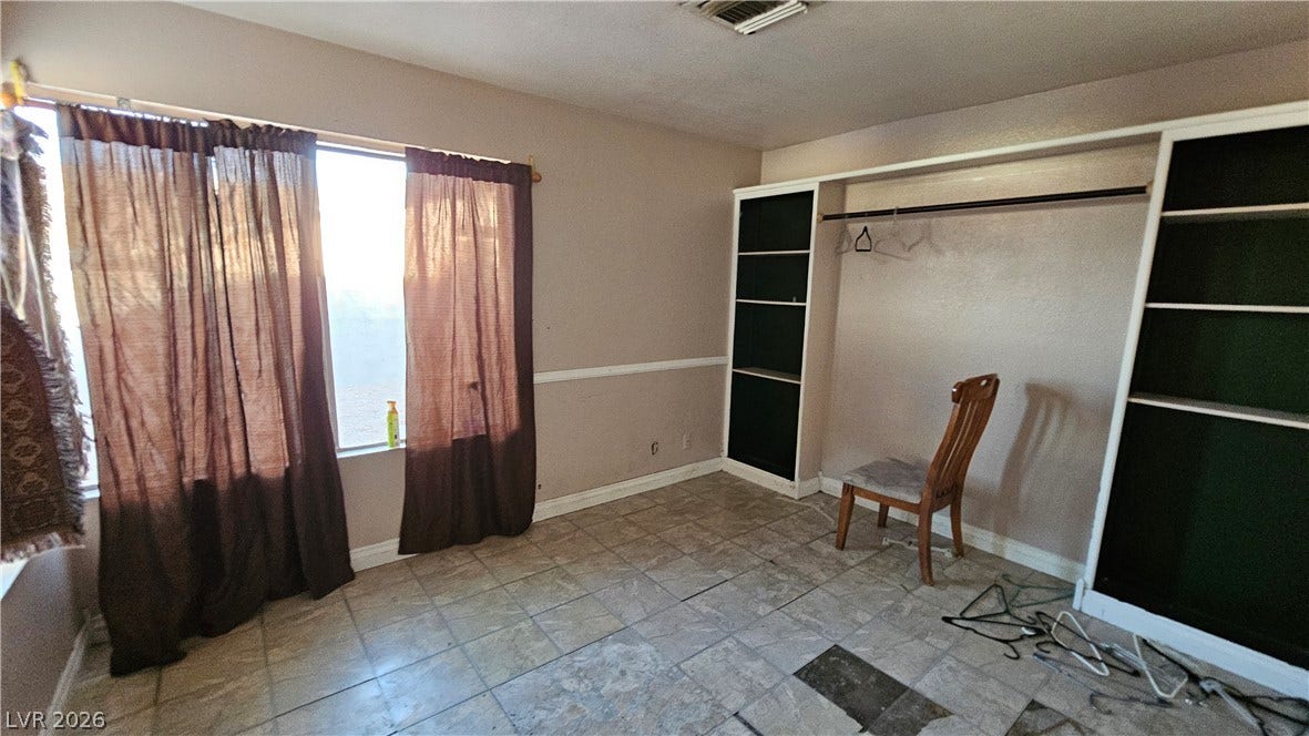 6777 Ledgewood Drive, Las Vegas, NV 89103 Tiled flooring and built-in shelving anchor this versatile room illuminated by natural light.