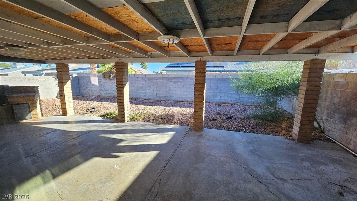 6777 Ledgewood Drive, Las Vegas, NV 89103 An expansive covered patio provides shaded outdoor living space overlooking the fenced backyard.