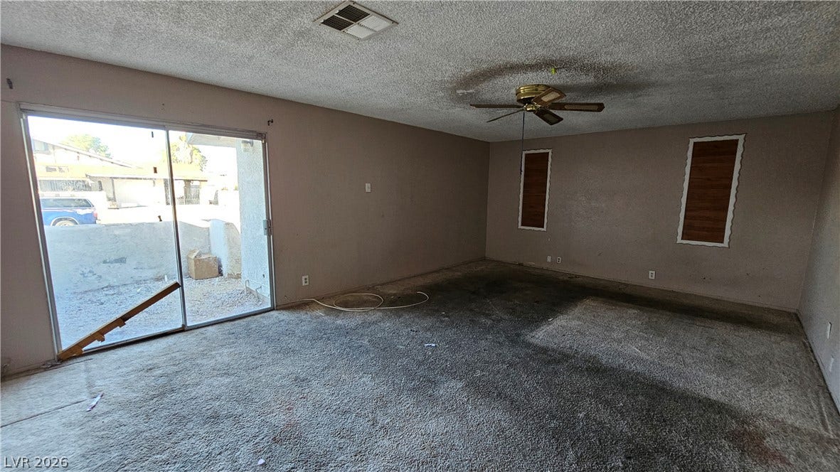 6777 Ledgewood Drive, Las Vegas, NV 89103 Sliding glass doors open to the outdoors from this carpeted living space.